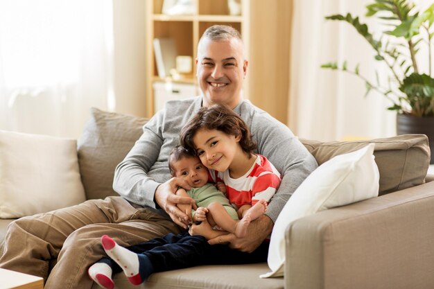 un père heureux avec un préadolescent et un bébé à la maison