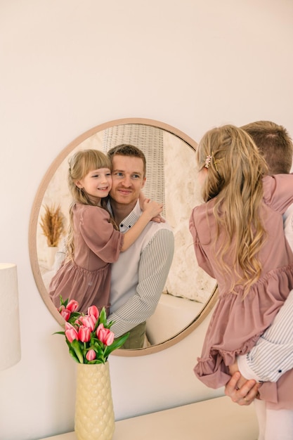 Un père heureux avec sa fille reflétée dans le miroir.