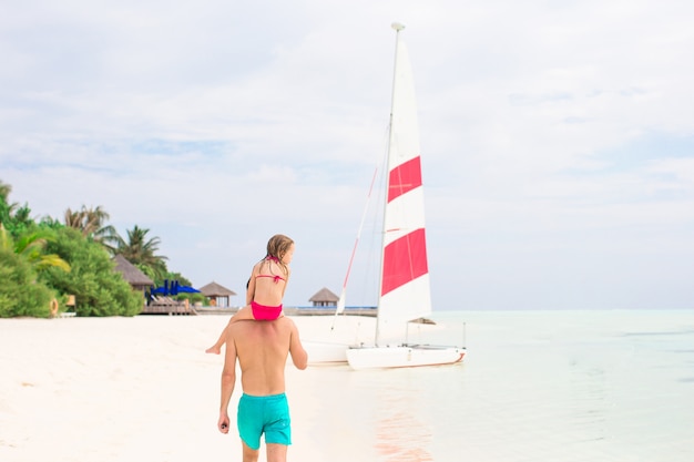 Père heureux et sa petite fille adorable à la plage tropicale s'amuser