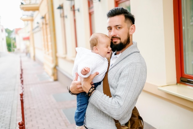 Père hipster tenant bébé Portrait de famille dans la ville Père avec un enfant pour une promenade