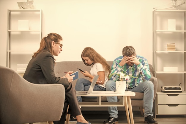 Un père inquiet parle à un psychologue de famille de la dépendance au téléphone d'un enfant accro au téléphone