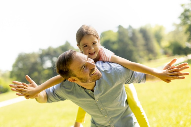 Père avec une jolie petite fille s'amusant au parc