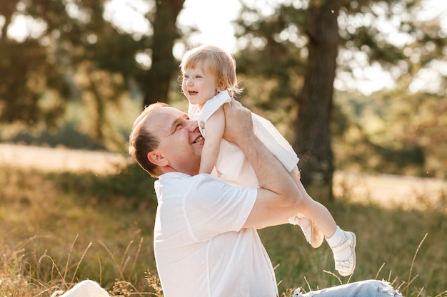 Père jouant avec bébé fille dans le parc dans la nature en vacances d'été