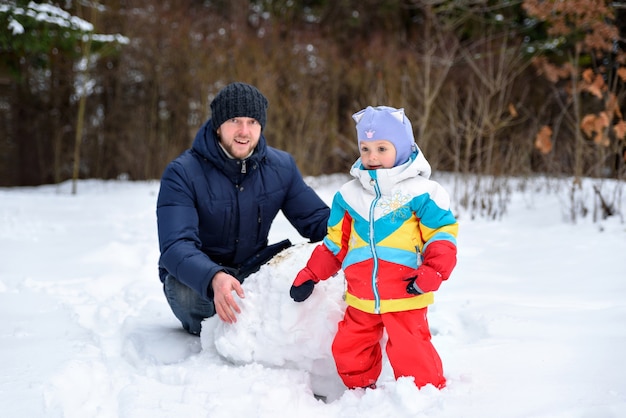 Photo père jouant avec son enfant dans la neige