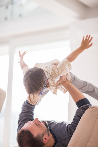 Père jouant avec son petit fils sur le canapé à la maison