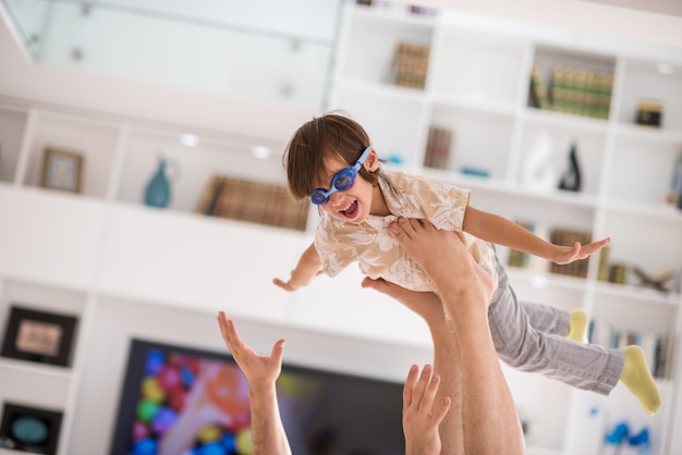 Père jouant avec son petit fils sur le canapé à la maison