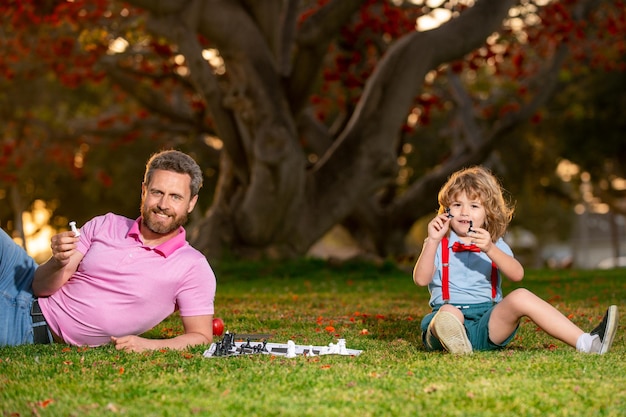 Le père joue aux échecs avec des jeux de fils et des divertissements pour les enfants concept de famille