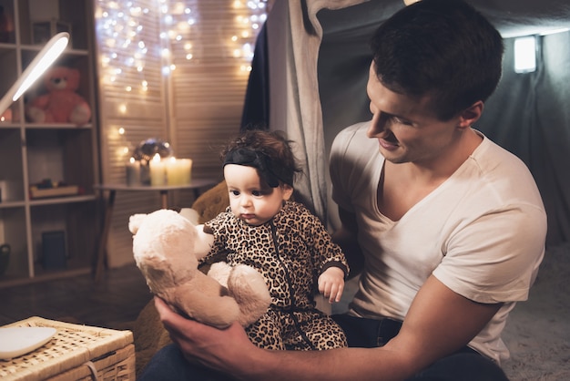 Père joue avec petite fille bébé dans la couverture