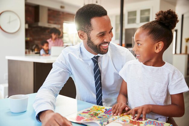 Père lisant un livre avec sa fille avant d'aller travailler