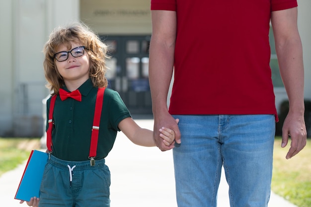 Père marchant fils à l'école Parent et nerd élève d'écolier de l'école primaire avec sac à dos