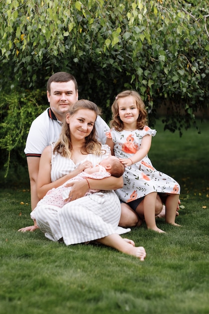 Père, mère et deux enfants, petite fille et petite fille sur l'herbe le jour d'été