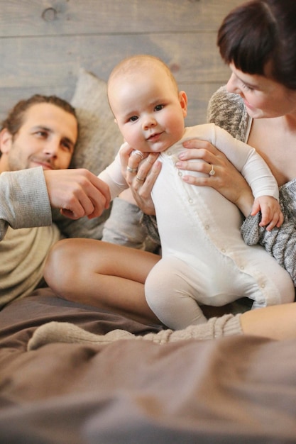 Un père mère et un jeune bébé jouant à la maison