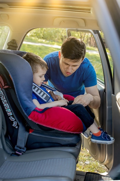 Père mettant bébé dans un siège d'auto de sécurité papa et enfant ensemble voyage en famille vacances mode de vie transport enfant enfant dos à la route