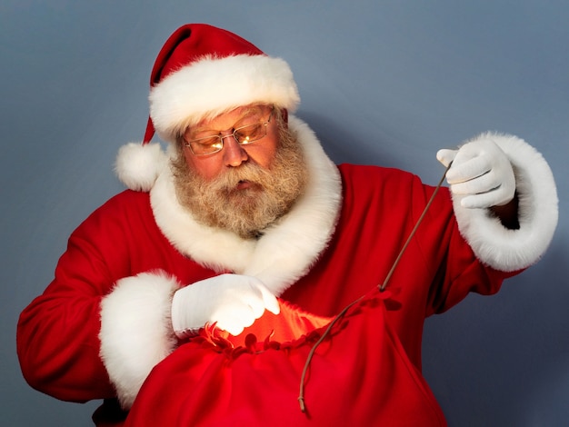 Le Père Noël attache son sac avec des cadeaux.