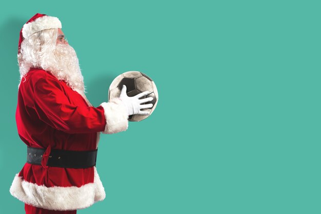 Père Noël Avec Un Ballon De Football Dans Ses Mains Isolé Sur Un Fond De Couleur Menthe