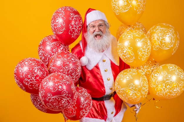 Père Noël avec des ballons en arrière-plan