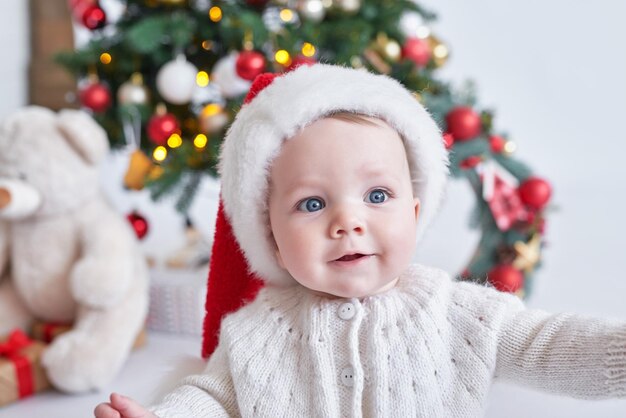 Père Noël bébé arbre de Noël fond bonne année enfant dans le chapeau du père Noël