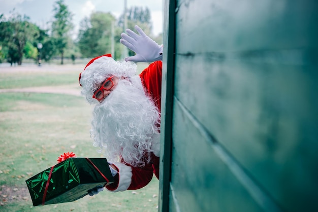 Père Noël avec boîte-cadeau sur fond de boisThaïlandaisEnvoyé du bonheur pour les enfantsJoyeux NoëlBienvenue en hiver