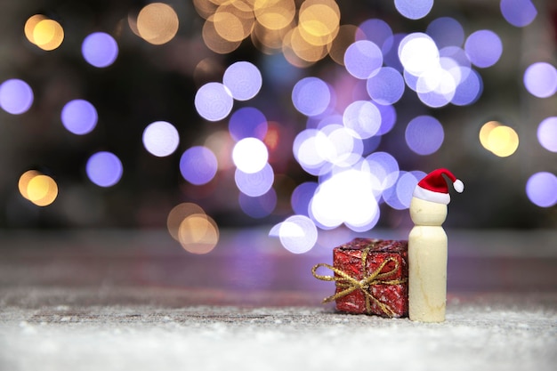 Père Noël avec boîte-cadeau de Noël rouge sur table en bois avec arrière-plan flou et espace de copie Merry Christmasholidaypresent concept