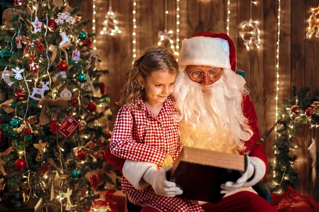 Père Noël donnant un cadeau à une petite fille mignonne