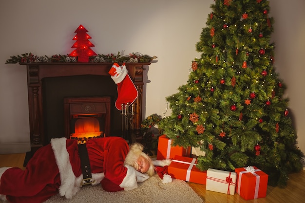 Père Noël dormant sur le tapis