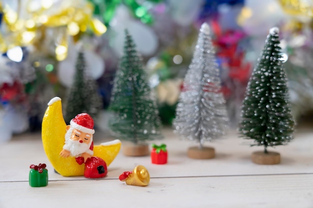 Le Père Noël dort dans la lune Croissant devant les arbres de Noël en attendant le festival amusant de Noël et la bonne année pour créer le bonheur de la carte de voeux et le concept amusant