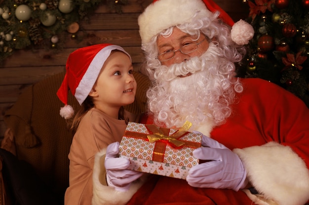 Père Noël et enfant à la maison. Cadeau de Noël. Concept de vacances en famille.