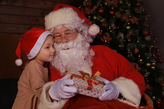 Père Noël et enfant à la maison. Cadeau de Noël. Concept de vacances en famille.