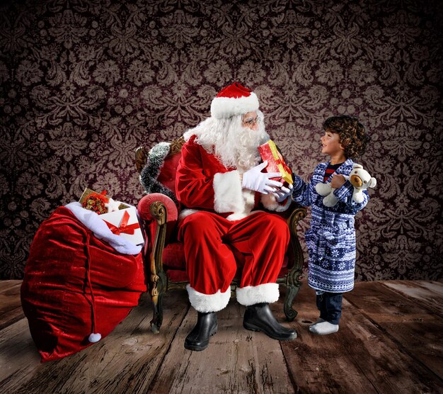 Photo le père noël est prêt à livrer des cadeaux de noël à un enfant.