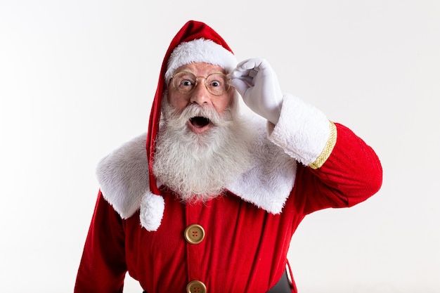 Le Père Noël à lunettes a l'air surpris par la caméra sur fond blanc