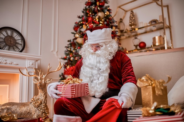 Le Père Noël met des cadeaux dans son grand sac rouge pour souhaiter un Joyeux Noël aux enfants.