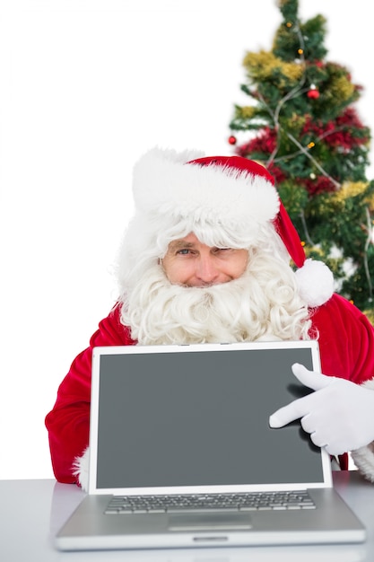 Père Noël montrant son ordinateur portable