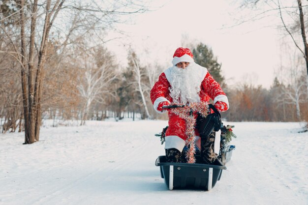 Père Noël à motoneige dans la forêt d'hiver