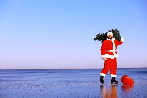 Le Père Noël en patins à glace va à Noël. Le Père Noël se dépêche de rencontrer le Nouvel An avec des cadeaux et un arbre de Noël.