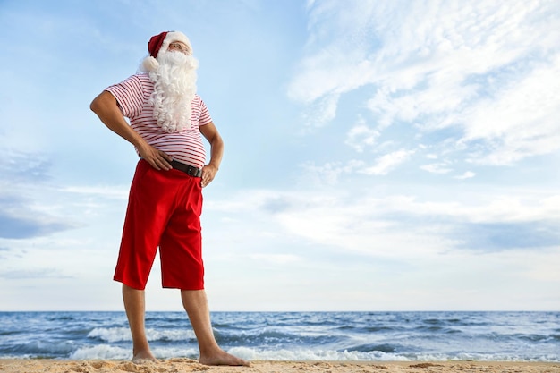 Père Noël sur la plage espace pour texte vacances de Noël