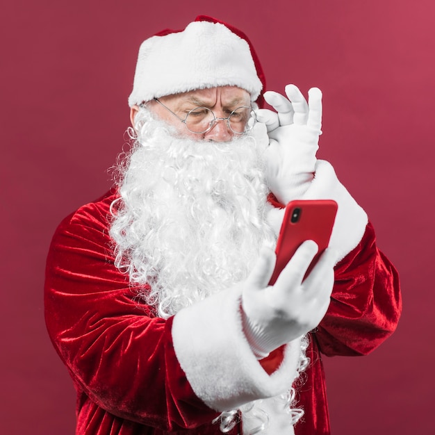 Photo père noël regardant l'écran du téléphone