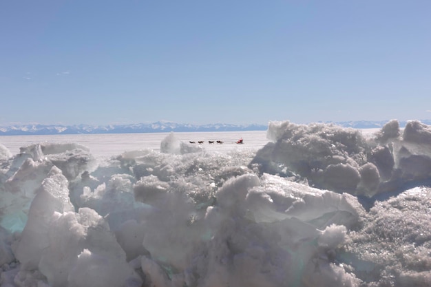 Le Père Noël se promène en traîneau à chiens sur un lac gelé