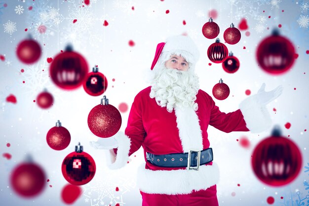 Photo le père noël avec ses mains contre le motif de flocon de neige