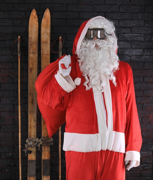 Photo père noël avec des skis en bois