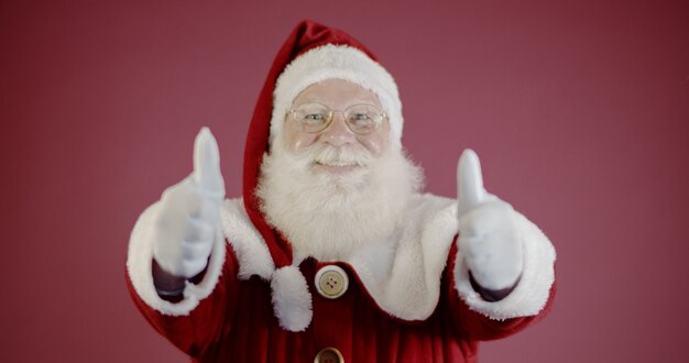 Père Noël souriant en regardant la caméra.