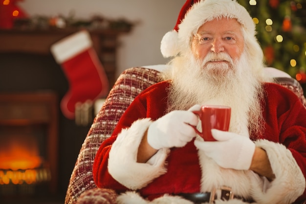 Père Noël souriant tenant une tasse