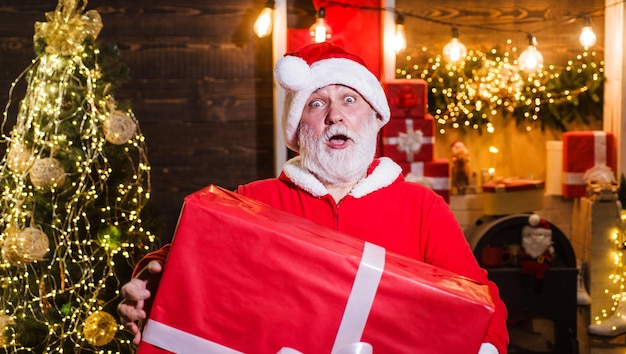 Père noël surpris avec boîte-cadeau santa man avec grand présent publicité de nouvel an joyeux noël