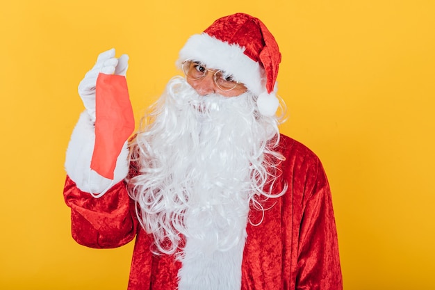 Père Noël tenant un masque rouge, sur jaune