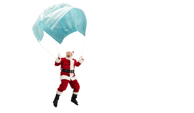 Père noël volant sur un énorme masque facial comme sur un ballon isolé sur fond blanc