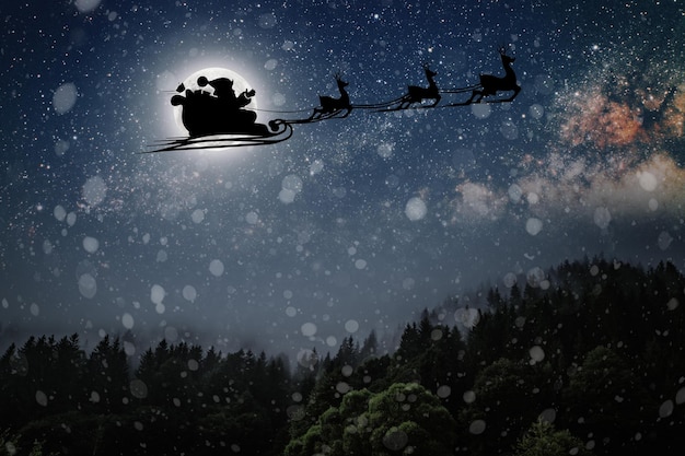 Le Père Noël vole la veille de Noël dans le ciel nocturne avec de la neige