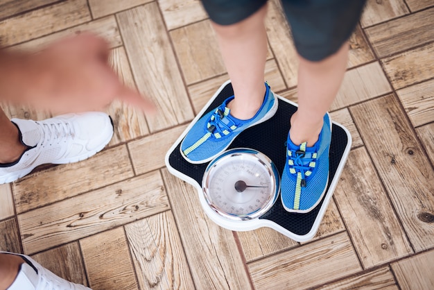 Le père pèse son fils sur la balance.