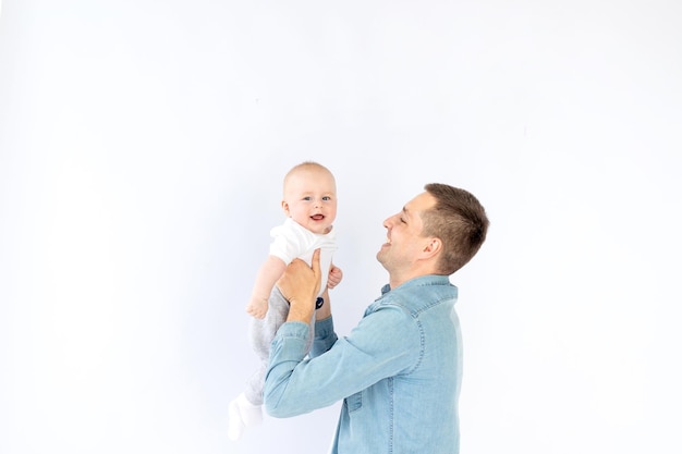 Un père avec un petit enfant fils sur un fond blanc vide isolé dans un studio photo jouant étreindre Bonne paternité ou famille