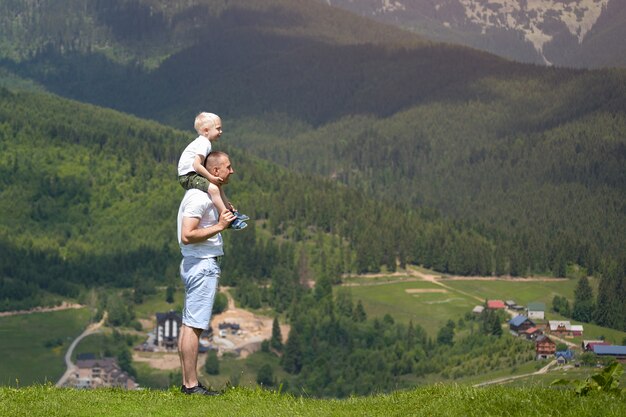 Père avec un petit fils sur ses épaules.