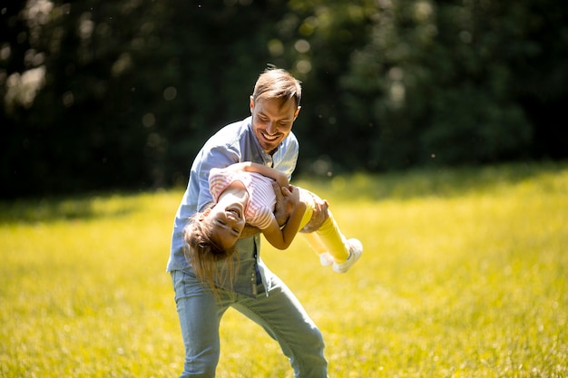Père avec une petite fille mignonne s'amusant sur l'herbe du parc