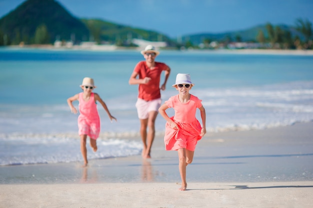 Photo père et petits enfants profitant des vacances tropicales à la plage